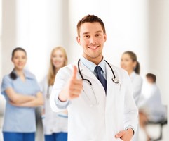 healthcare and medical concept - doctor with stethoscope showing thumbs up